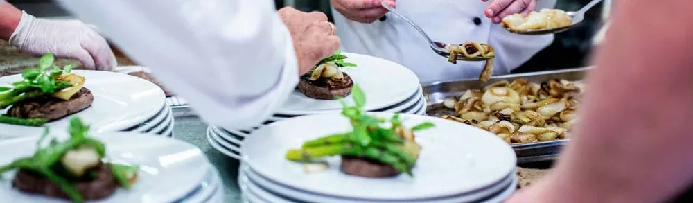 Busy restaurant kitchen with staff maintaining high food hygiene standards
