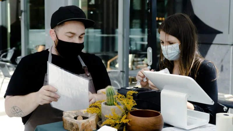 EHO inspector checking temperature records in restaurant kitchen