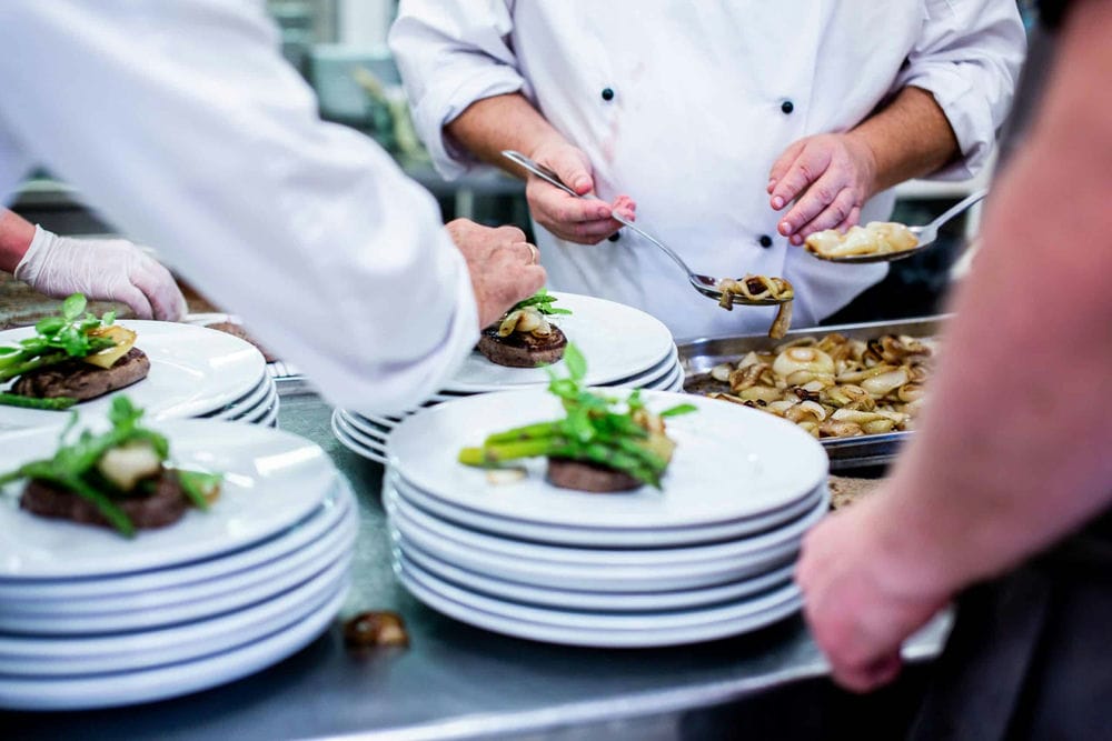 Busy restaurant kitchen with staff maintaining high food hygiene standards